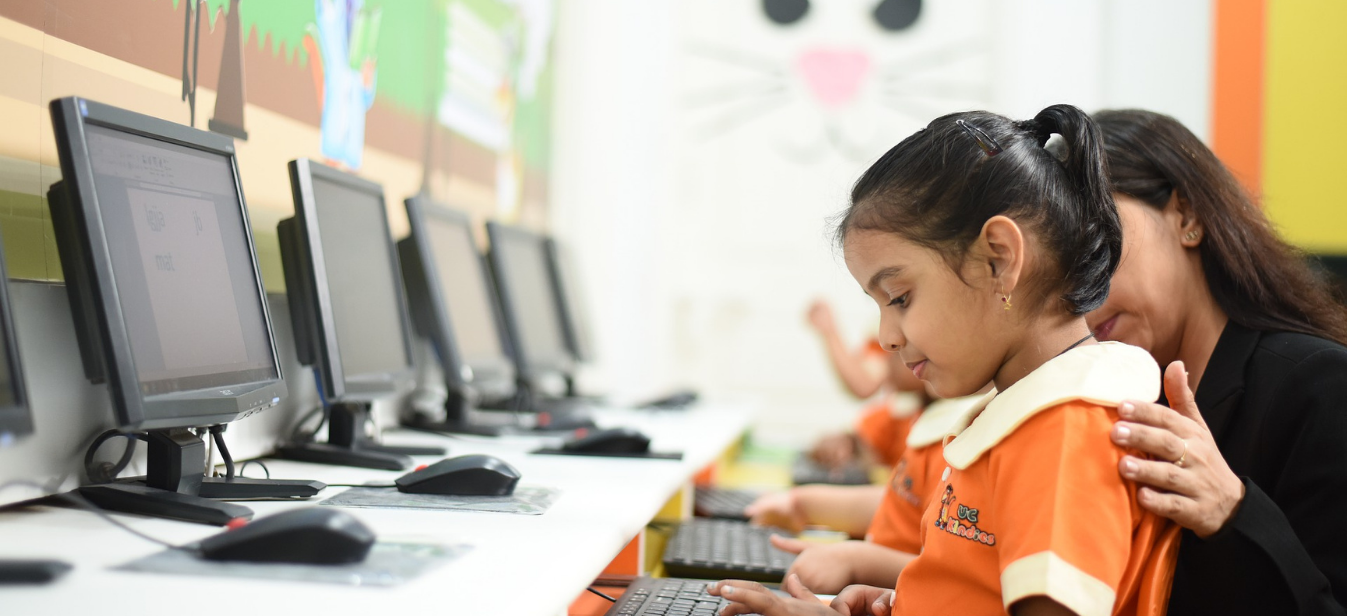 A teacher guiding a child to develop digital literacy skills